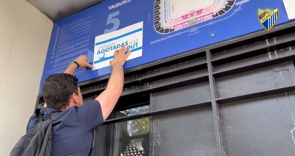 Un trabajador del Málaga cuelga el cartel de entradas agotadas en las taquillas de La Rosaleda. Captura/MalagaCF