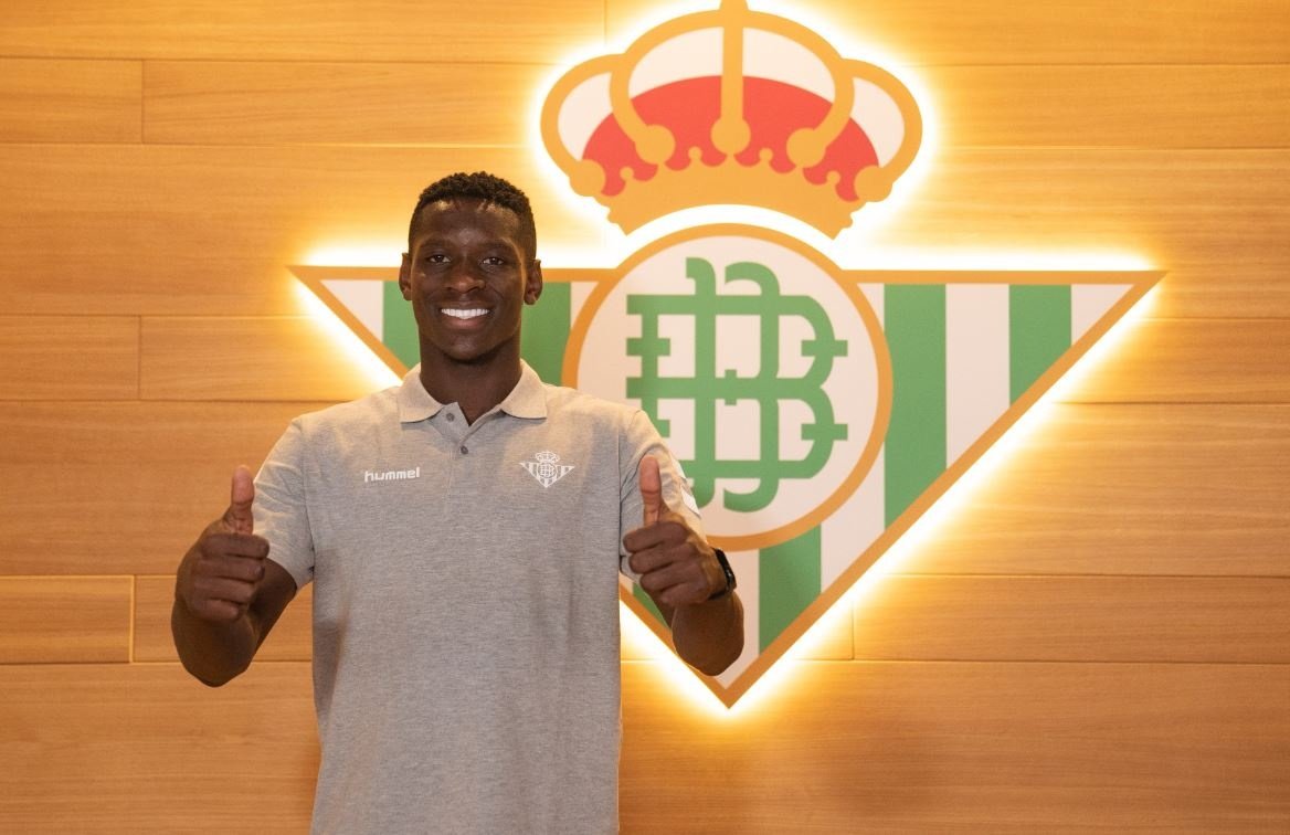 Luiz Henrique posa ante un escudo del Real Betis en el antepalco del Benito Villamarín. RBB