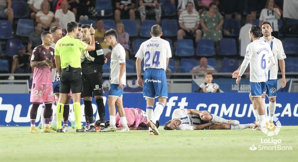 Juanfran, en el suelo, se queja de la falta de Gallego en la acción polémica del penalti entre el Tenerife y el Málaga CF. LaLiga