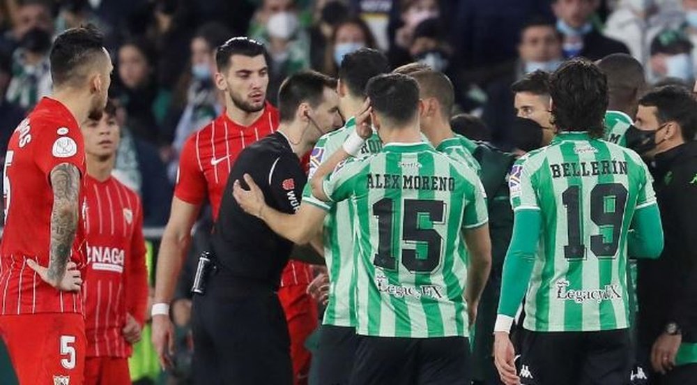 Jugadores del Real Betis y el Sevilla FC conversan con De Burgos durante el último derbi en el Benito Villamarín. Efe