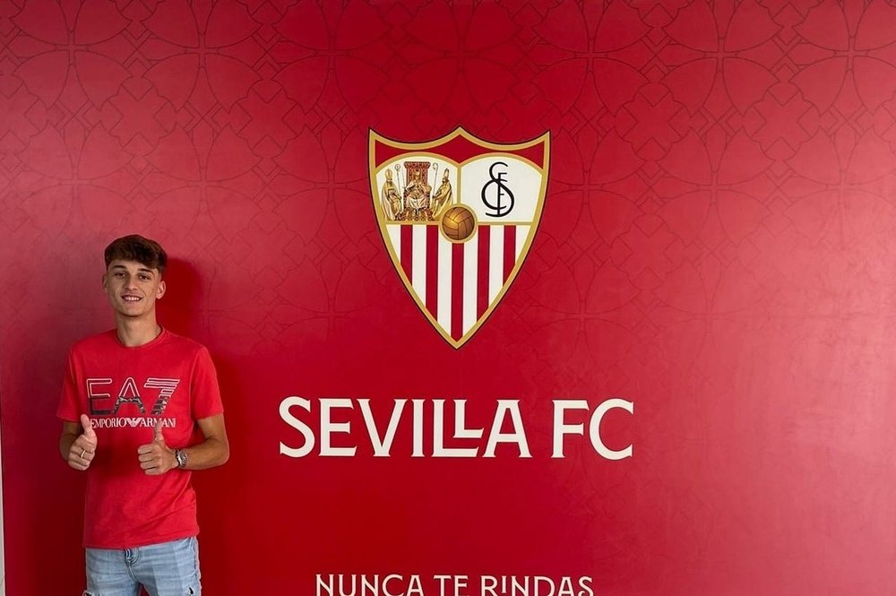 Imagen de Juanan Aguilera posando con el escudo del Sevilla FC | Imagen: @CanteraSFC