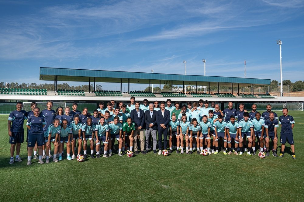 Los jugadores del Betis Deportivo y las del Real Betis Féminas posan en la Nueva Ciudad Deportiva Rafael Gordillo junto al presidente del Real Betis, Ángel Haro, Rafael Gordillo y Joaquín Sánchez.- RBB