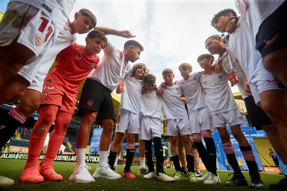 Los futbolistas del conjunto Alevín del Sevilla FC escuchan atentamente las indicaciones antes de el inicio del partido.- SFC