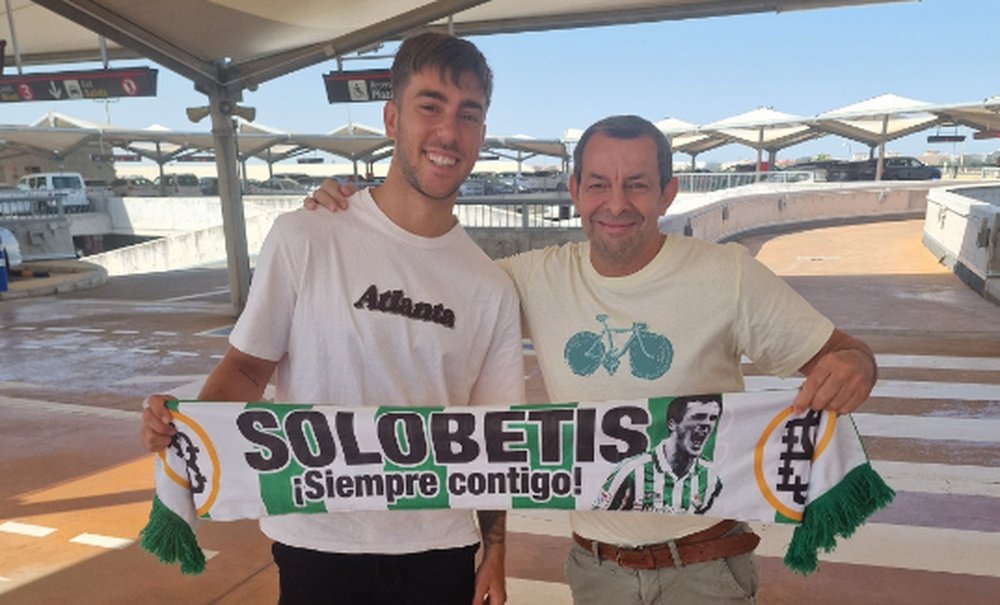Iker Losada posa con un aficionado bético a su llegada al aeropuerto.- JMC