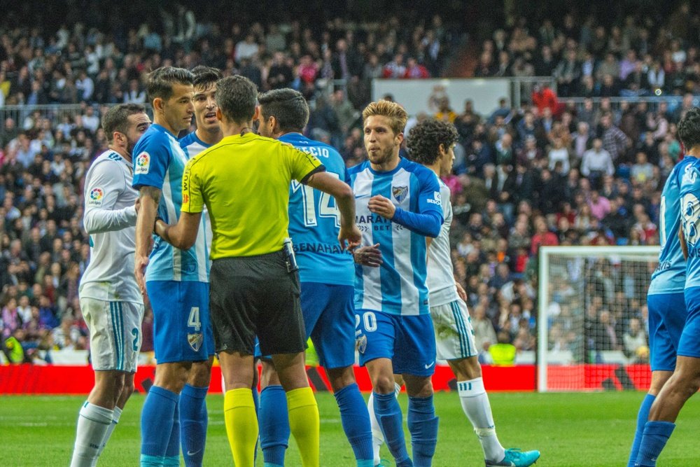 Jogadores do Málaga rodeiam o árbitro. BeSoccer
