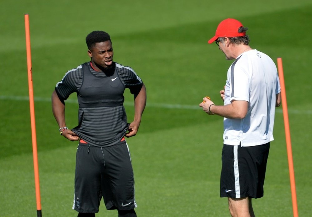 Paris Saint-Germains head coach Laurent Blanc (R) talks to Ivorian defender Serge Aurier before a training session at the Camp des Loges in Saint-Germain-en-Laye on April 14, 2015