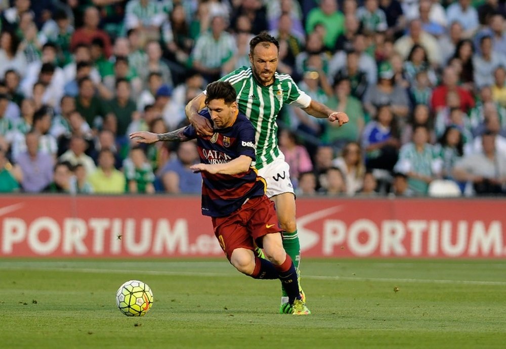 Barcelonas Lionel Messi fights off a challenge from Real Betis Balompies Heiko Westermann. BeSoccer