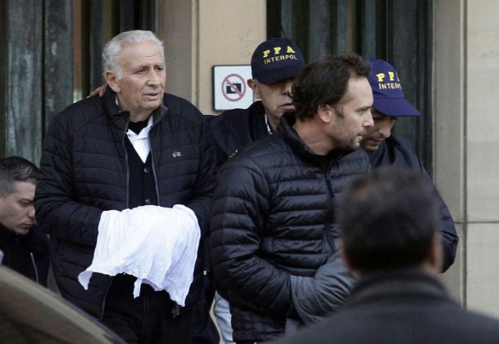 Argentinian Hugo (C-L) and Mariano (C-R) Jinkis, father and son, owners of sports marketing company Full Play, are escorted as they leave court in Buenos Aires on June 18, 2015