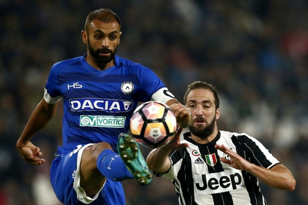 Udinese defender and captain Danilo Larangeira (L) challenges Juventus forward Gonzalo Higuain for the ball during the Italian Serie A match at the Juventus Stadium in Turin on October 15, 2016