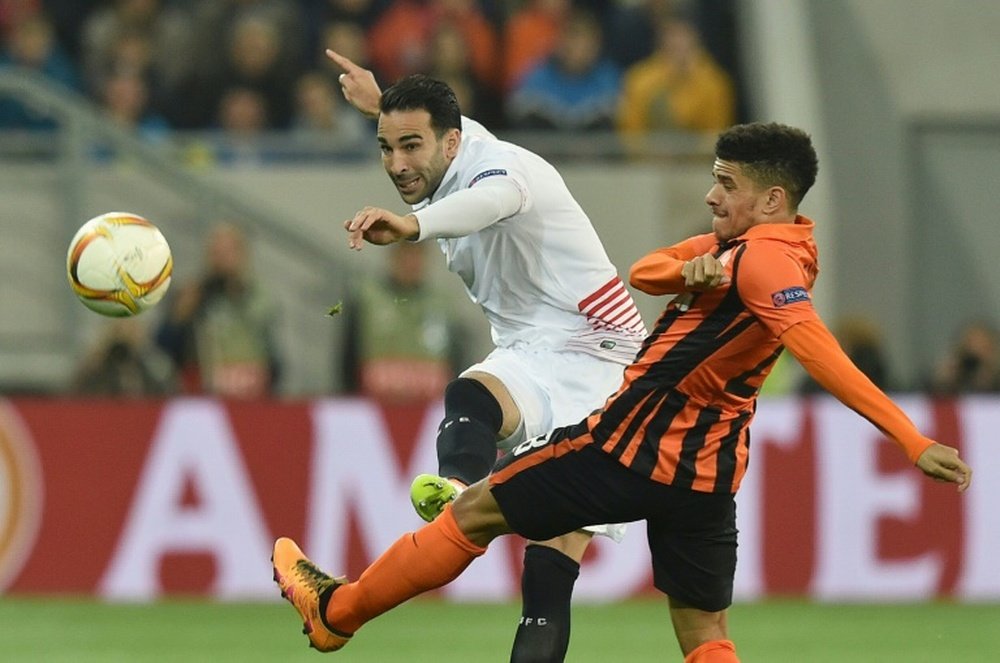 Taison (R) of FC Shakhtar vies for a ball with Adil Rami (L) of Sevilla FC during the UEFA Europa League semi-final football match at the Arena Lviv stadium in Lviv on April 28, 2016