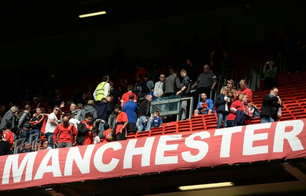 Fans evacuate Old Trafford stadium in Manchester, England, after the English Premier League football match between Manchester United and Bournemouth was abandoned on May 15, 2016