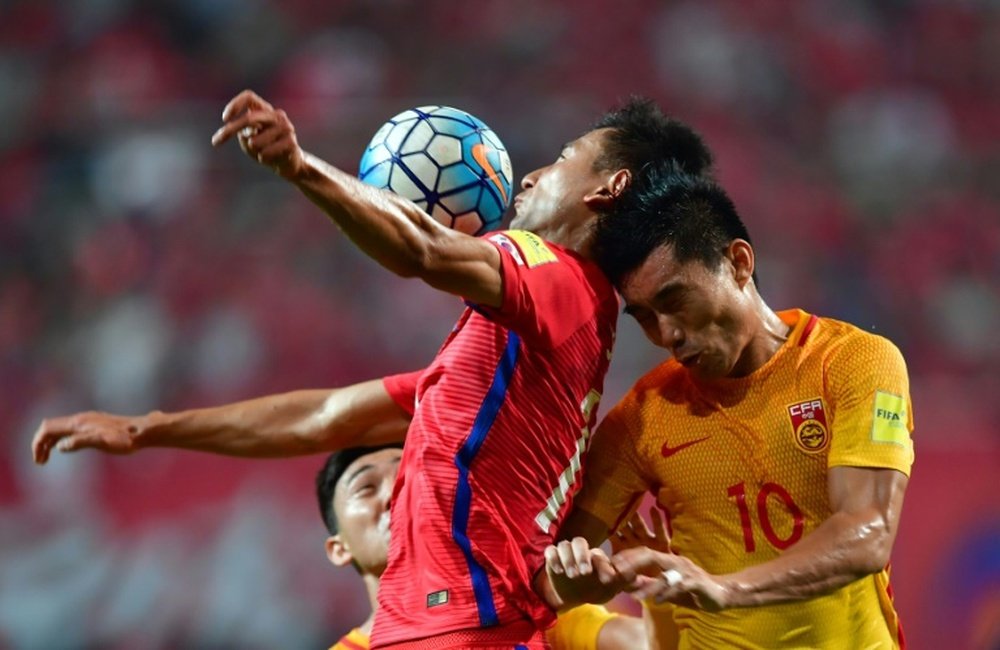 South Koreas Ji Dong-Won (L) fights for the ball with Chinas Zheng Zhi (R). AFP