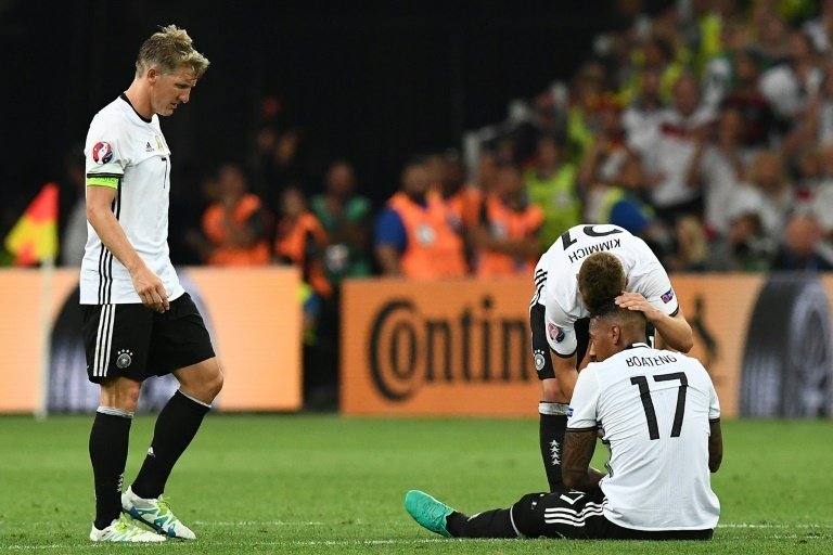 Germanys Bastian Schweinsteiger (L) looks on as Joshua Kimmich speaks with Jerome Boateng during the Euro 2016 semi-final on July 7, 2016