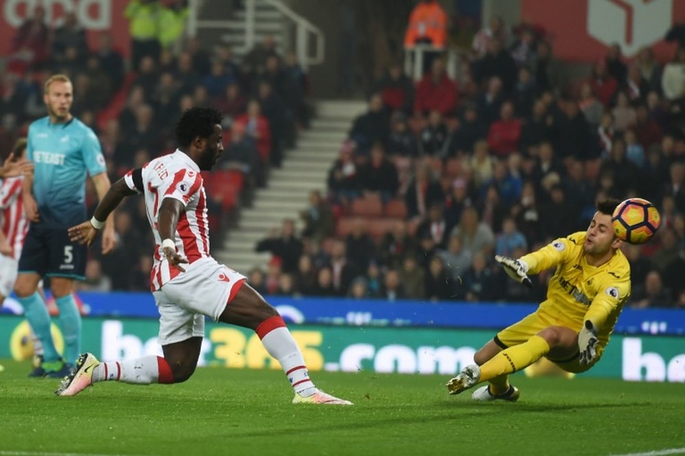 Stoke Citys striker Wilfried Bony (L) shoots and scores past Swansea Citys goalkeeper Lukasz Fabianski during the English Premier League football match between Stoke City and Swansea in Stoke-on-Trent, central England on October 31, 2016