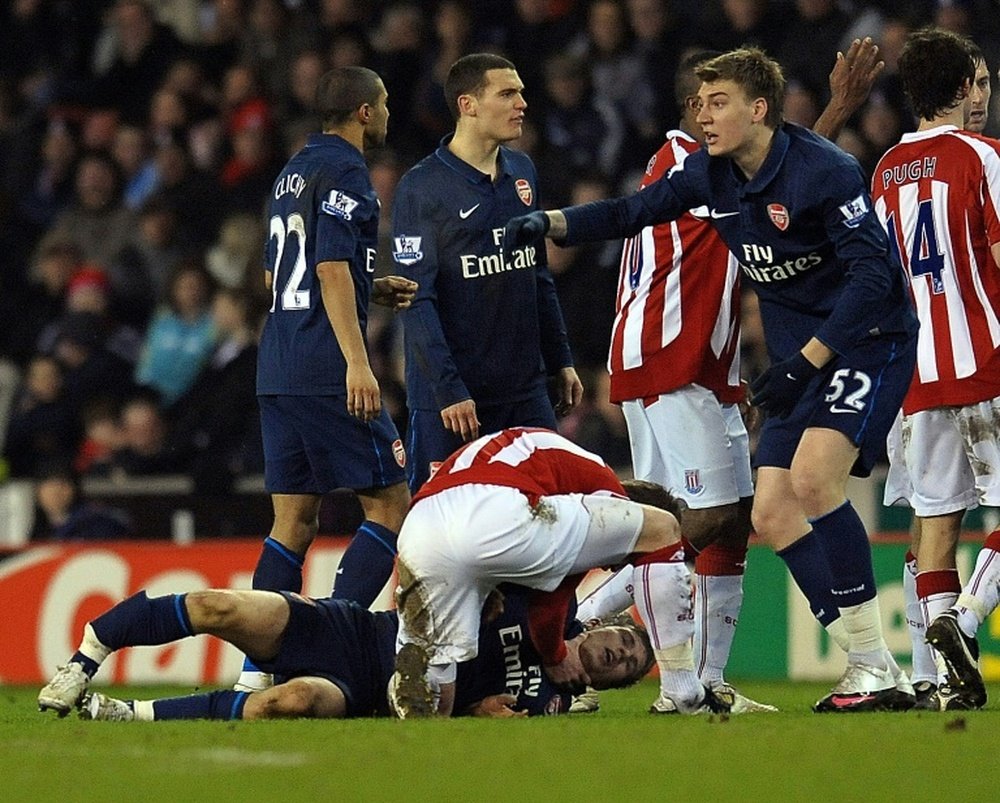 Stoke city's Glenn Whelan attends to Arsenal's Aaron Ramsey in 2010. AFP