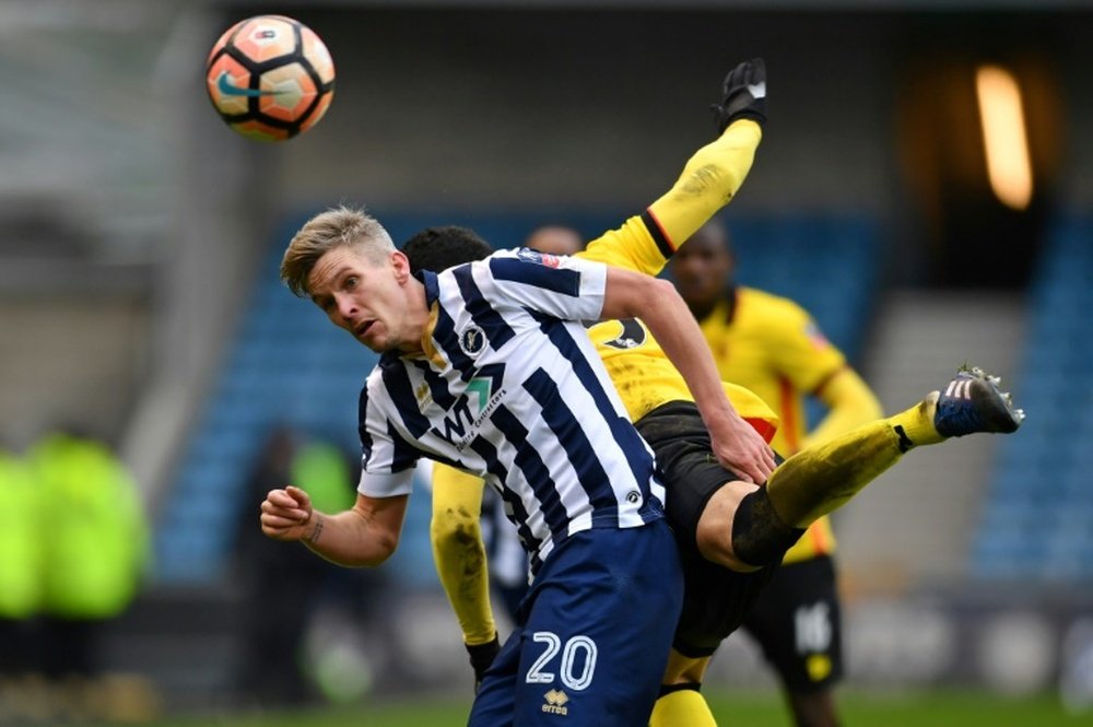 Millwall's Steve Morison (left) views with Watford's Miguel Britos. AFP