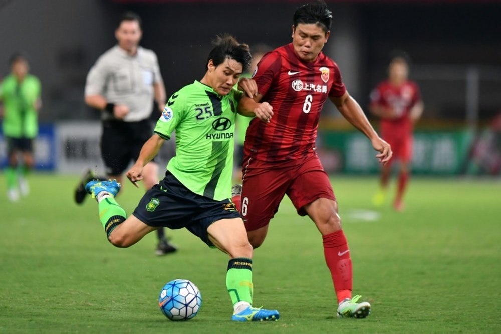 Cai Huikang (R) of China's Shanghai SIPG fights for the ball with Choi Chul Soon. AFP