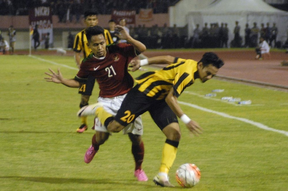 Indonesias Andik Vermansyah (back) challenges Mohd Azrif Nasrulhaq Badrul Hisham of Malaysia during their friendly football match in Solo on September 6, 2016