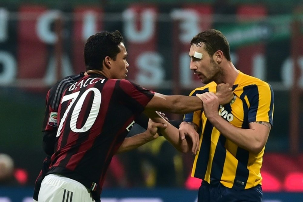Verona midfielder Artur Ionita (R) argues with Milan forward Carlos Bacca during the Italian Serie A football match in Milan on December 13, 2015
