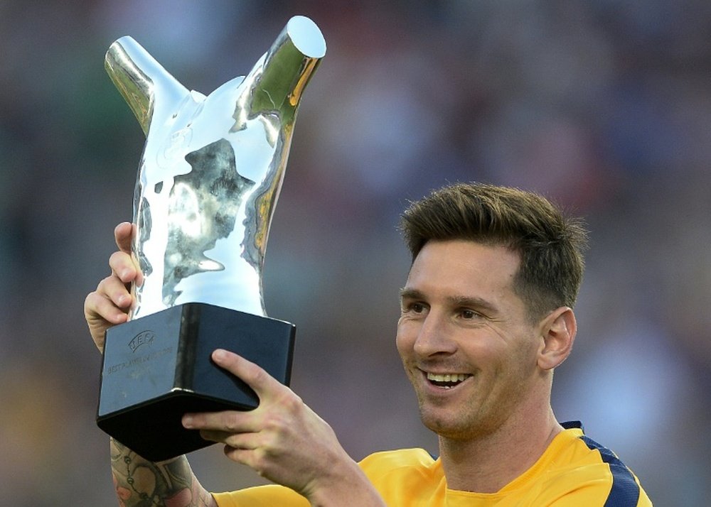 Barcelonas Argentinian forward Lionel Messi lifts up his UEFA Best Player in Europe Award before the Spanish league football match FC Barcelona vs Malaga CF at the Camp Nou stadium in Barcelona on August 29, 2015