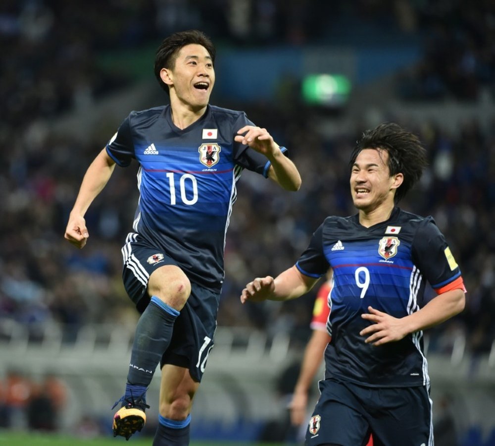 Japan forward Shinji Kagawa (left) celebrates a goal against Syria in Saitama on March 29, 2016