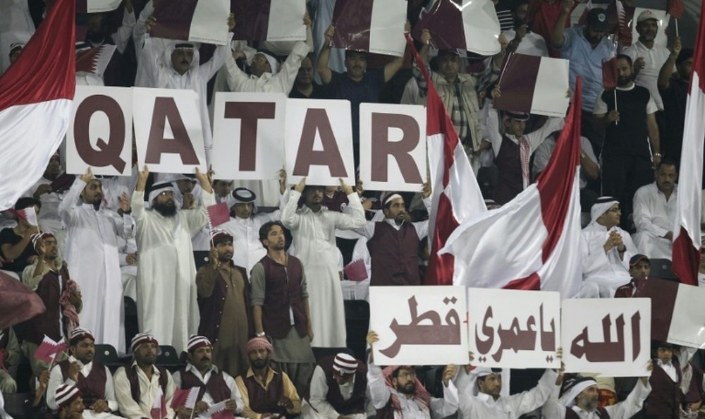 Qatari fans hold banners to show their support for their national team during the group B 2014 World Cup Asian qualifying football match between Qatar and South Korea in Doha on June 8, 2012