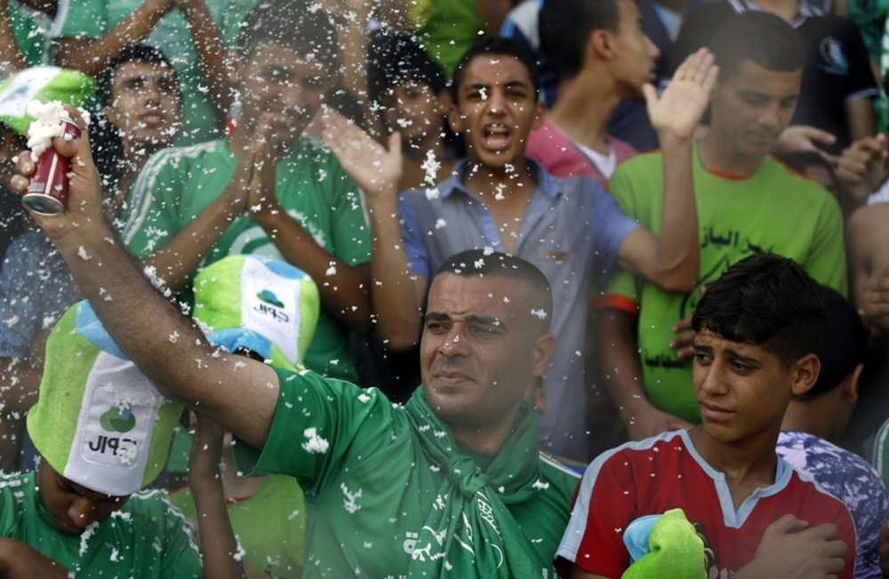 Palestinian spectators cheer during a football match between the West Bank-based Al-Ahli and Gazas Shejaiya, playing each other for the first time in 15 years, at the al-Yarmuk stadium in Gaza City on August 6, 2015