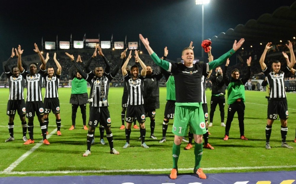 Angers goalkeeper Ludovic Butelle (R) and his teammates cheer the crowd after holding Paris Saint-Germain to a 0-0 draw on December 1, 2015, at the Jean Bouin stadium