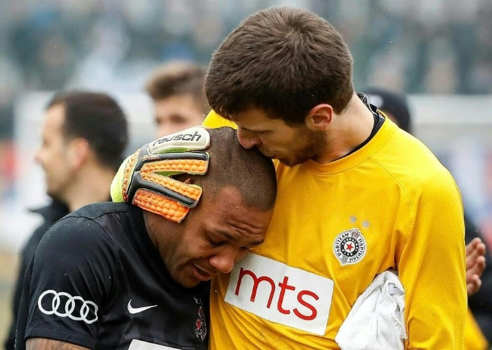 Partizan Belgrades goalkeeper Filip Kljajic (right) hugs Everton Luiz as he leaves the field. AFP