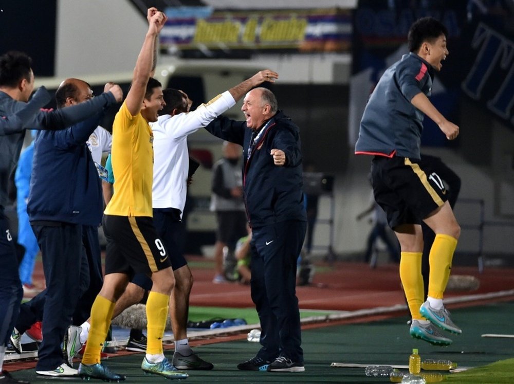 Chinas Guangzhou Evergrande head coach Luiz Felipe Scolari (C) celebrates with team players after the AFC Champions League semi-final football match against Japans Gamba Osaka on October 21, 2015