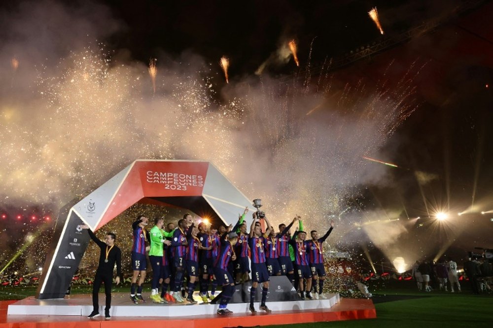Xavi lifted his first trophy as Barca coach. AFP