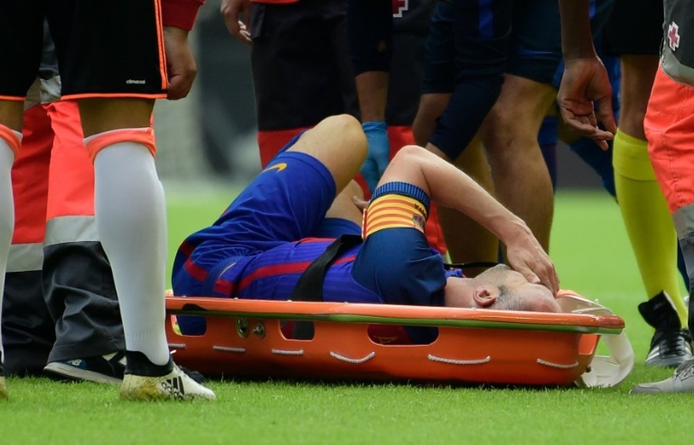 Andres Iniesta gestures on a stretcher after being injured against Valencia. AFP