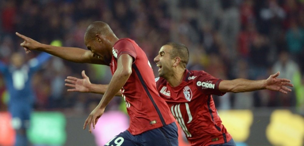 Lilles French defender Djibril Sidibe (L) celebrates with Lilles Moroccan midfielder Mounir Obbadi during the French L1 football match between Lille and Montpellier on October 2, 2015 in Villeneuve dAscq, northern France