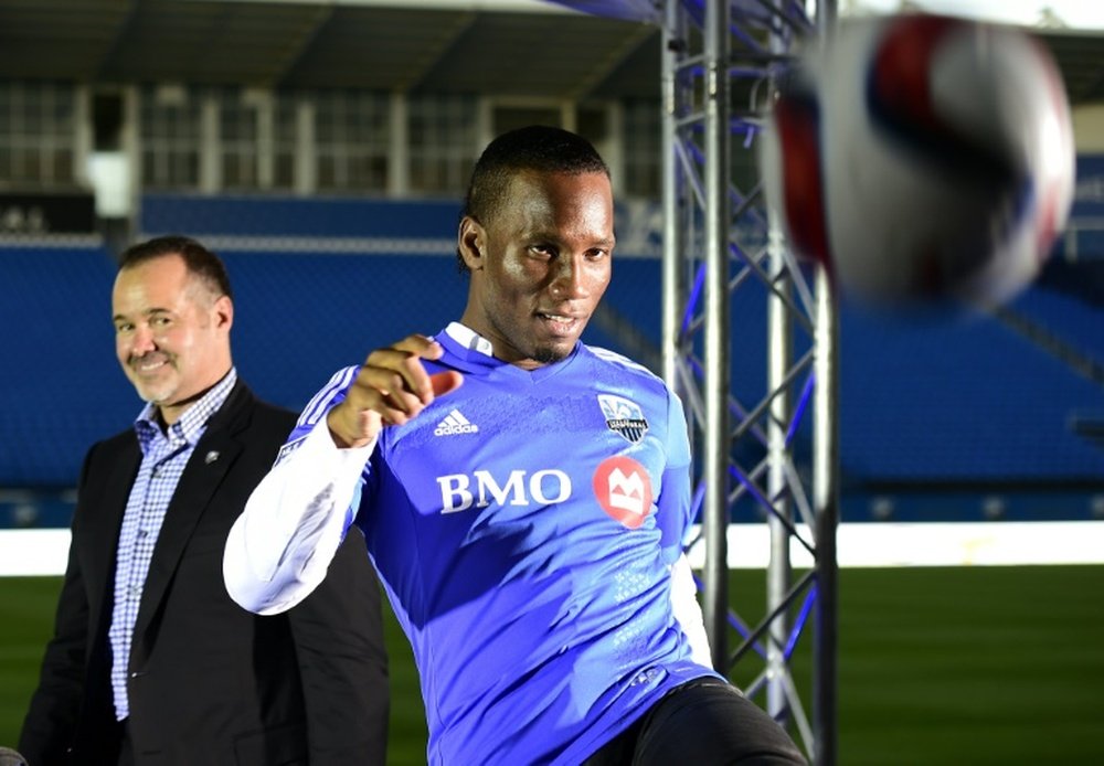 Ivorian striker Didier Drogba kicks the ball in front of Montreal Impact president Joey Saputo after a press conference on July 29, 2015 in Montreal