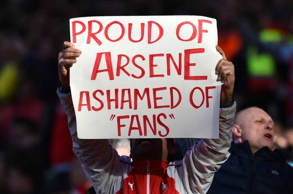 An Arsenal fan holds up a sign in support for Arsenals French manager Arsene Wenger. BeSoccer