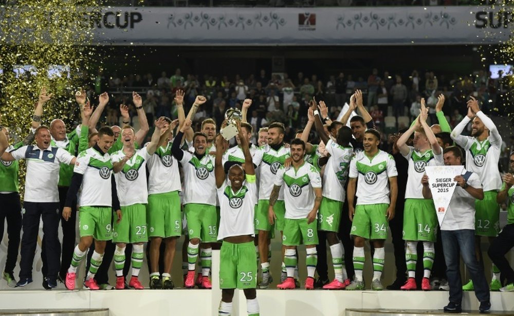 Wolfsburgs players and Wolfsburgs head coach Dieter Hecking (R) celebrate after winning the German Supercup football match VfL Wolfsburg vs Bayern Munich in Wolfsburg, central Germany, on August 1, 2015