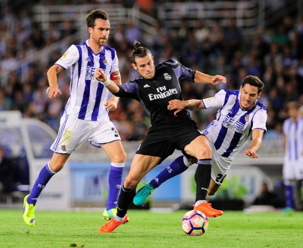 Real Madrids forward Gareth Bale (C) clashes with Real Sociedads defender Joseba Zaldua (R) at the Anoeta stadium in San Sebastian on August 21, 2016