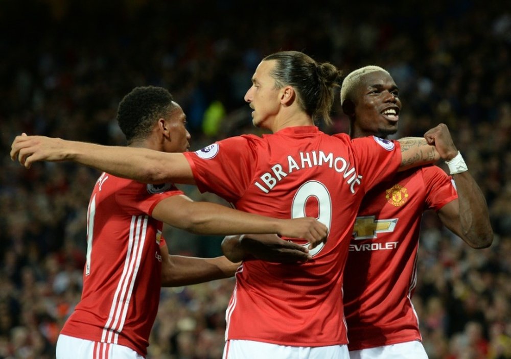 Manchester Uniteds Zlatan Ibrahimovic (C) celebrates with Paul Pogba (R) and Anthony Martial after scoring a goal from the penalty spot during their English Premier League match against Southampton, at Old Trafford in Manchester, on August 19, 2016