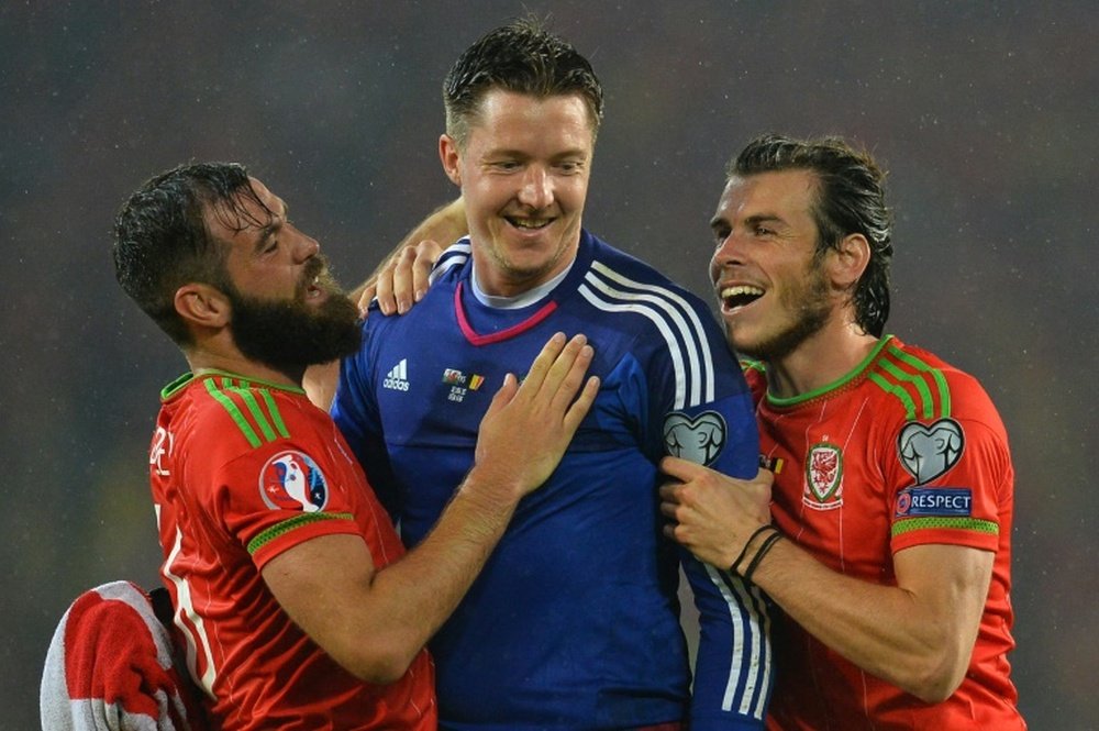 Wales players Gareth Bale (right) and Joe Ledley (left) celebrate with goalkeeper Wayne Hennessey after victory against Belgium in Cardiff on June 12, 2015