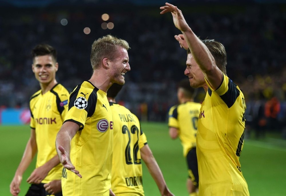 Dortmunds Andre Schuerrle (C) celebrates with teammate Lukasz Piszczek after scoring a goal during their UEFA Champions League first leg match against Real Madrid, at BVB stadium in Dortmund, on September 27, 2016