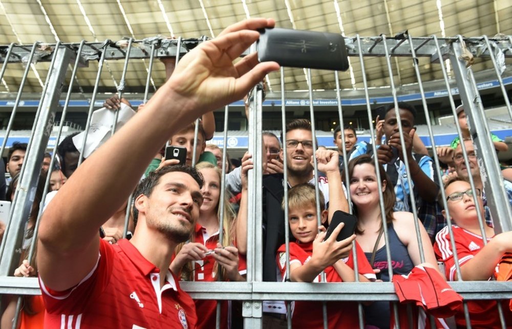 Bayern Munichs new defender Mats Hummels takes a selfie with supporters after a training session in Munich, southern Germany, on August 6, 2016