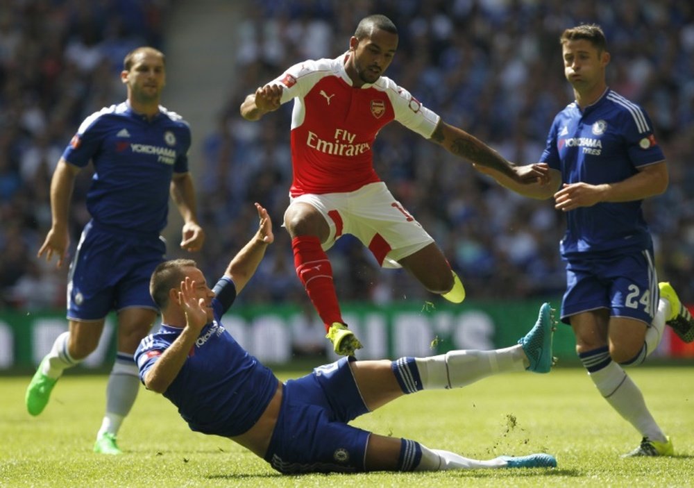 Arsenals English midfielder Theo Walcott evades the challenge from Chelseas English defender John Terry (2nd L) during the FA Community Shield football match between Arsenal and Chelsea at Wembley Stadium in north London on August 2, 2015