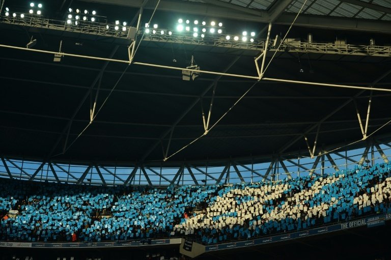 Manchester Citys supporters hold up blue and white cards ahead of the English League Cup final football match between Liverpool and Manchester City at Wembley Stadium in London on February 28, 2016