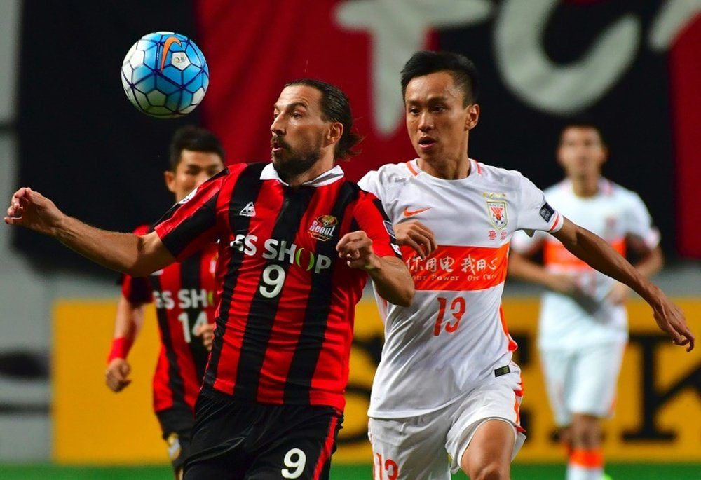 FC Seoul forward Dejan Damjanovic (left) fights for the ball with Shandong Luneng's Zhang Chi. AFP