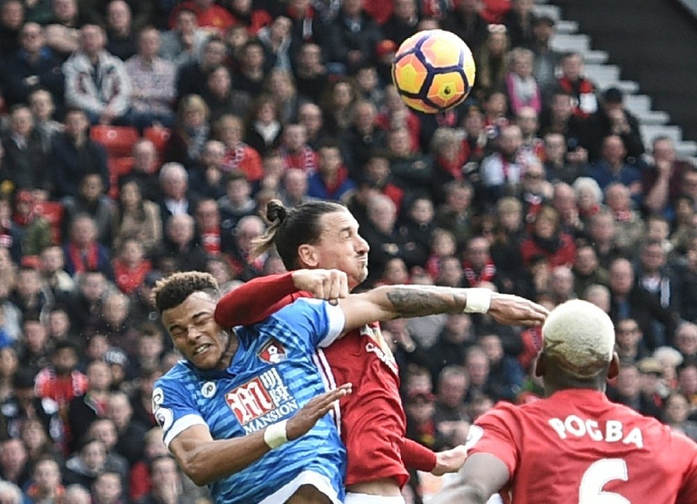 Zlatan Ibrahimovic clashes in the air with Bournemouths defender Tyrone Mings. AFP