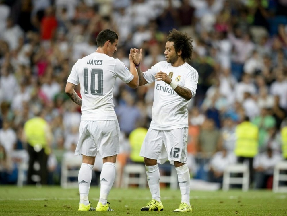 Real Madrids defender Marcelo (R) celebrates a goal with teammate James Rodriguez during the match Real Madrid vs Galatasaray at the Santiago Bernabeu stadium in Madrid on August 18, 2015