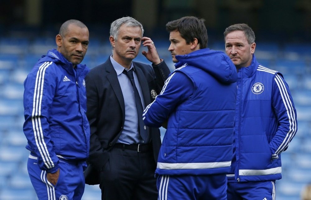 Chelsea manager Jose Mourinho (2nd left) stands with his coaching staff on the pitch after his side