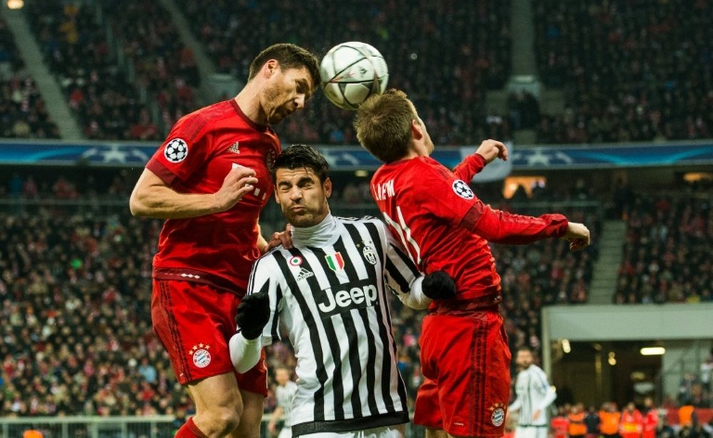 Bayern Munichs Xabi Alonso (L), Juventus Mirko Vucinic (C) and Bayern Munichs Philipp Lahm go head to head during the match in Munich, on March 16, 2016