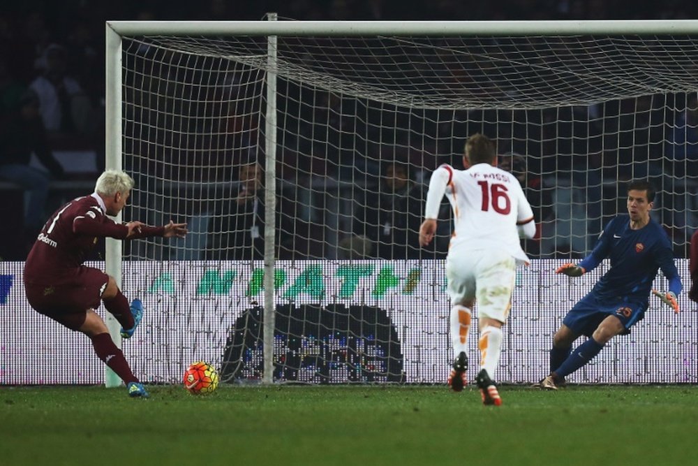 Torinos forward Maxi Lopez (L) kicks and scores a penalty against Romas goalkeeper Wojciech Szczesny during an Italian Serie A football match on December 5, 2015 at the Olympic Stadium in Turin