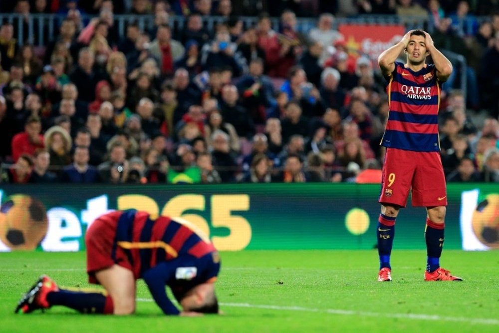 FC Barcelonas forwards Lionel Messi (L) and Luis Suarez (R) gesture after missing a goal during the Spanish league football match FC Barcelona vs Deportivo de La Coruna at the Camp Nou stadium in Barcelona on December 12, 2015